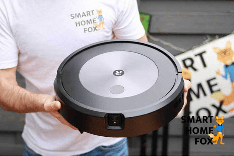 Робот-пылесос держат в руках, чтобы продемонстрировать дизайн и качество сборки iRobot Roomba